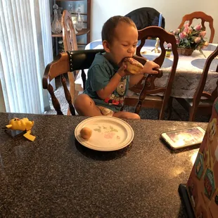 a toddler eating a donut