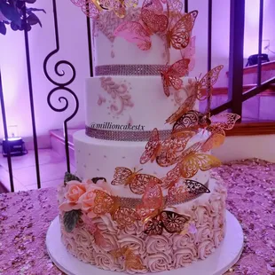 a three tiered cake decorated with butterflies