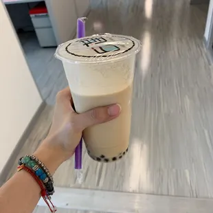 a hand holding a cup of milk tea