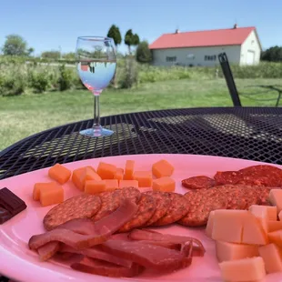 Cheese and meat plate with a glass of their Gemutlichkeit