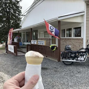 a hand holding a cone of ice cream