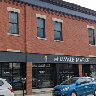 a blue car parked in front of the store