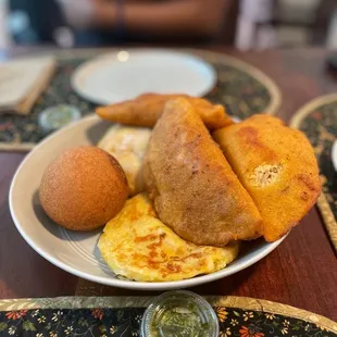 Mixture of our order: Colombian buñuelo, beef &amp; chicken empanadas, and one choclo arepa!