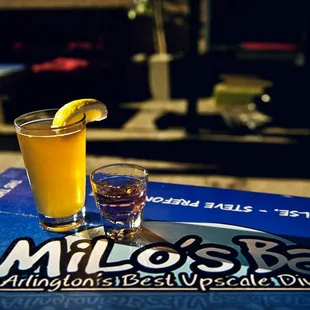 a glass of orange juice and a lemon wedge