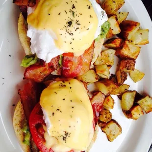 Eggs Benedict with bacon, tomato, and guacamole.