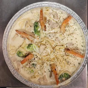 Fettuccini with homemade Alfredo sauce topped with Chicken, shrimp and broccoli