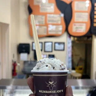 a hand holding a cup of ice cream