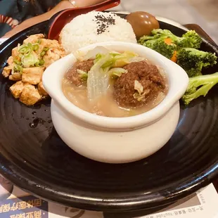 a bowl of soup, rice, and broccoli