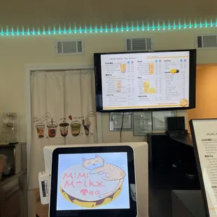 a coffee shop with a menu on the screen