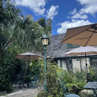 Garden patio with shade, tables and chairs.