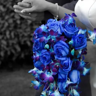 a bride holding a bouquet of blue roses