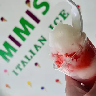 a hand holding a cup of ice cream