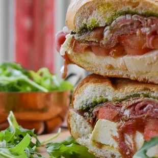 two sandwiches stacked on a cutting board