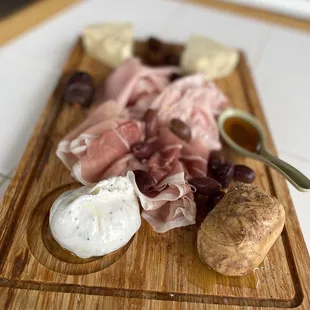 a cheese board with meats and cheeses