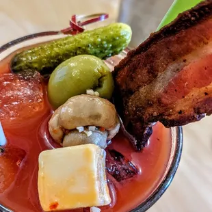 a bloody drink with bacon and pickles