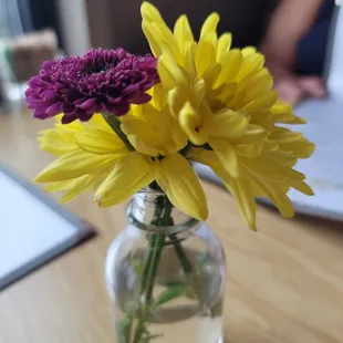 yellow and purple flowers in a glass vase