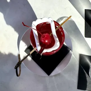 a red bowl with a cherry on it
