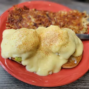 two eggs benedicts on a red plate