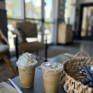 two cups of iced coffee and a basket of blueberries
