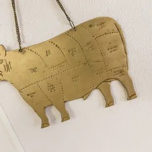 a brass cow hanging on a wall