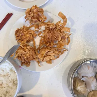 a plate of rice, a bowl of shrimp, and a bowl of fried chicken