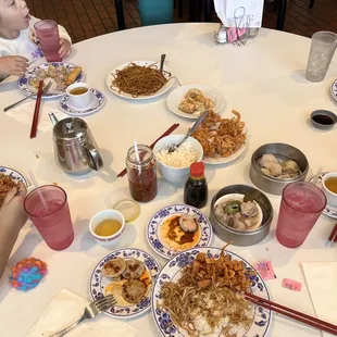 a group of people sitting at a table with plates of food