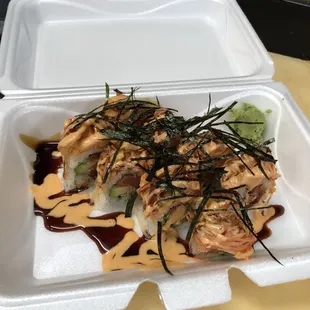a sushi roll in a styrofoam container