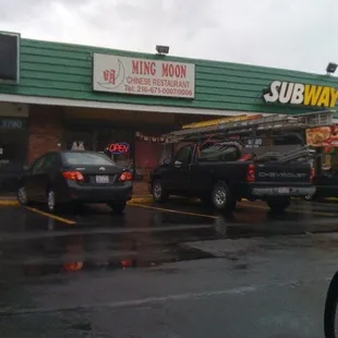 cars parked in front of a subway restaurant