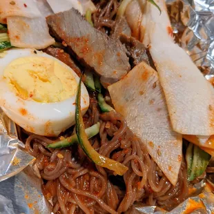 Bibim Naengmyeon. Korean cold buckwheat noodles, beef, radish, egg, cucumber, cold spicy sauce. $15.95.