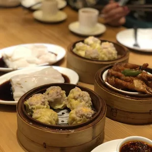 Siu mai pork dumplings (front and back), shrimp cheung fun rice noodles (left), chicken feet (right)