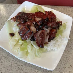 Bbq pork over rice with greens.