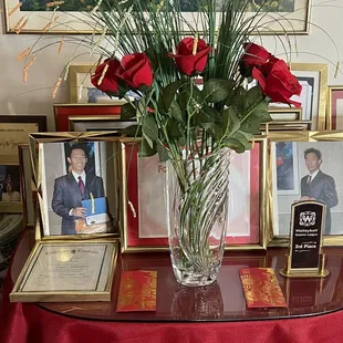 a vase of red roses on a table