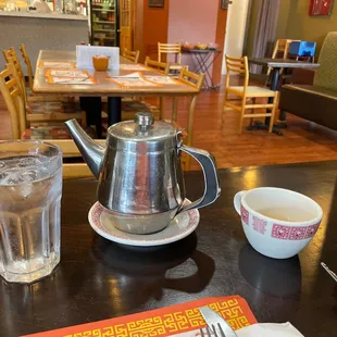 a teapot and a glass of water on a table