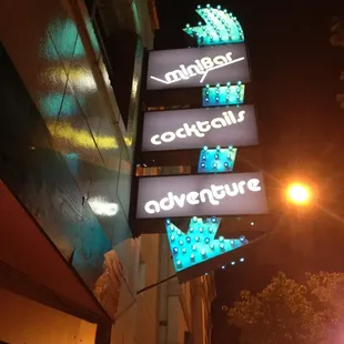a neon sign for a cocktail adventure