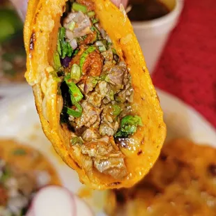 a hand holding a half eaten sandwich