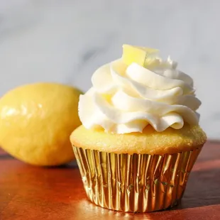a cupcake with whipped cream and a lemon