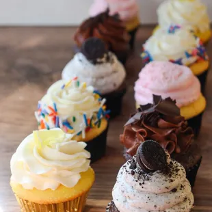 a row of cupcakes with frosting and sprinkles