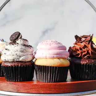 a variety of cupcakes on a stand