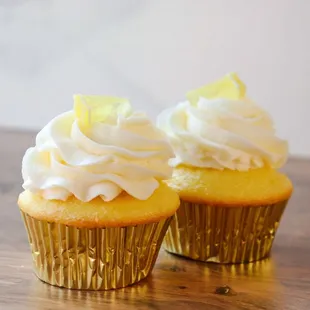two cupcakes on a wooden table