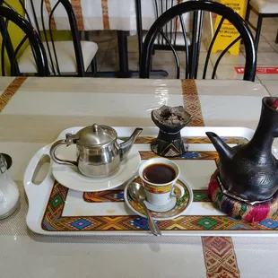 a tray with a tea pot and a cup of coffee