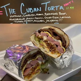 The Cuban Torta: hotdogs, chorizo ham, breaded beef, mozzarella, queso fresco, fried egg, lettuce, tomato, onions, jalapeños!!!