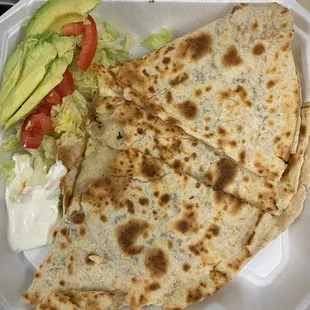 two quesadillas in a styrofoam container