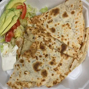 a close up of a small quesadilla in a styrofoam container