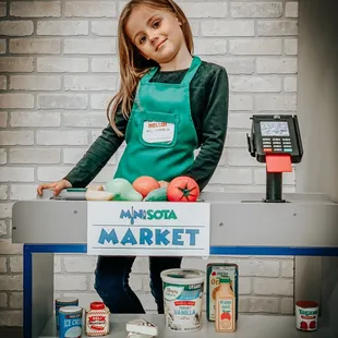 a little girl in a green apron
