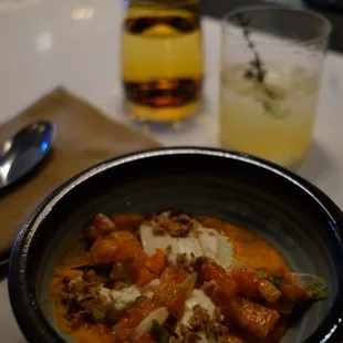 a bowl of food and a drink on a table