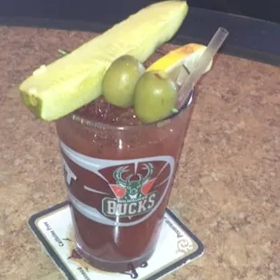 a bloody drink with olives and a banana