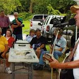 a man playing a guitar while people watch