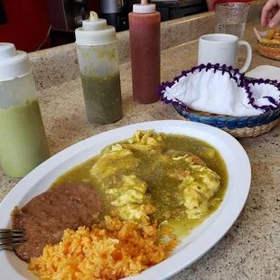 Huevos en salsa verde with homemade tortillas de maíz on the side. Three salsa options, french fries.