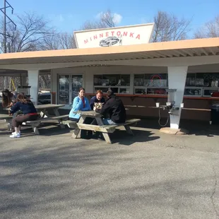 people sitting at picnic tables