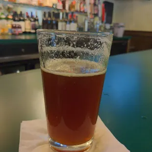 a glass of beer on a napkin